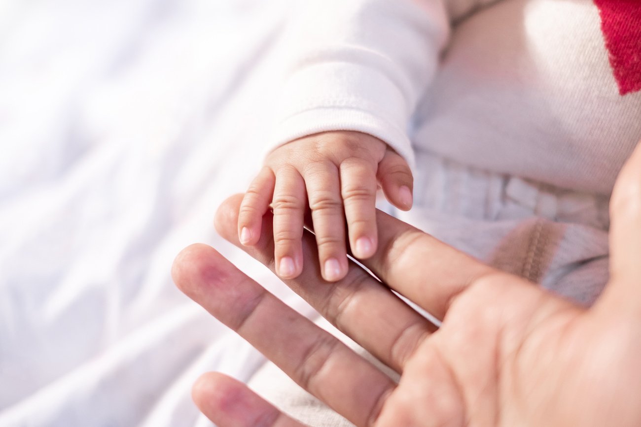 Baby’s Hand Touching an Adult’s Hand